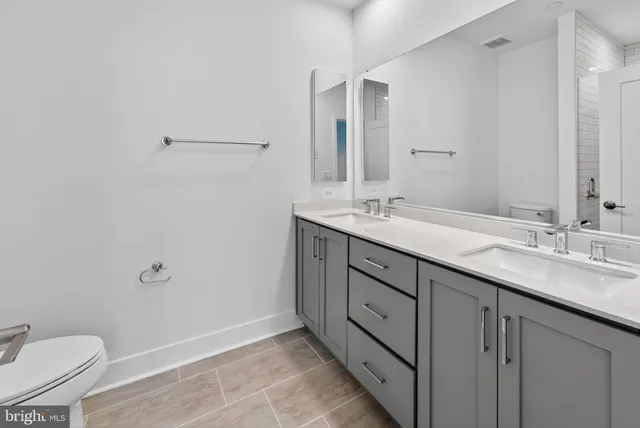 a bathroom with a granite countertop sink mirror and toilet
