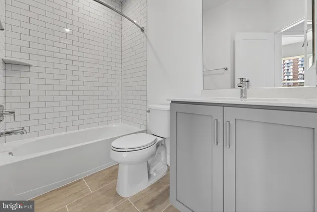 a bathroom with a toilet a sink a mirror and bathtub