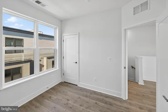 a view of a hallway with wooden floor and entryway