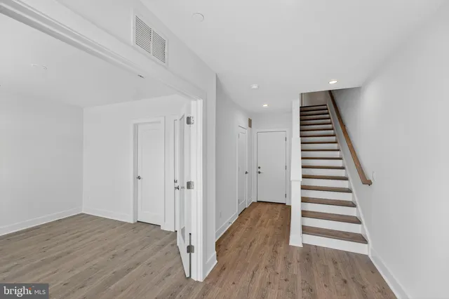 a view of a hallway with wooden floor and entryway
