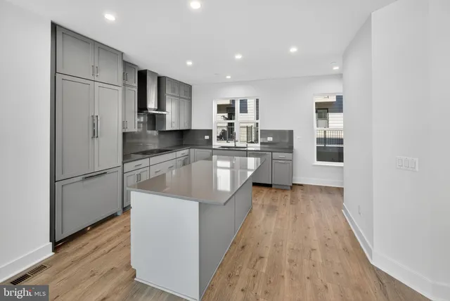 a kitchen with kitchen island a refrigerator a sink and wooden cabinets