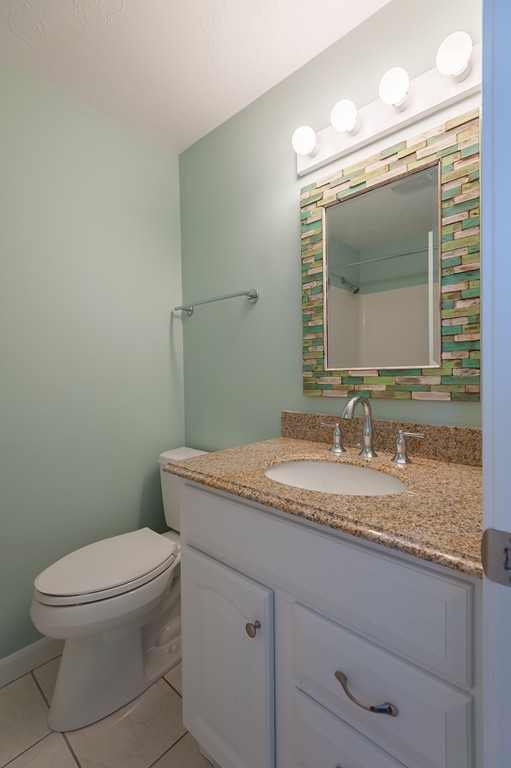 149 Jericho Road, Unit B Scituate, MA 02066 - Photo 14 of 22 a bathroom with a granite countertop toilet a mirror and a sink