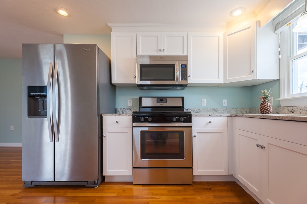 149 Jericho Road, Unit B Scituate, MA 02066 - Photo 6 of 22 a kitchen with stainless steel appliances white cabinets a sink and a stove