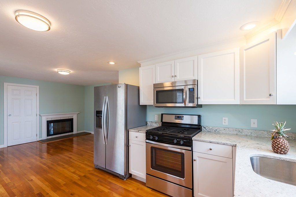 149 Jericho Road, Unit B Scituate, MA 02066 - Photo 7 of 22 a kitchen with stainless steel appliances granite countertop a stove a sink and a refrigerator