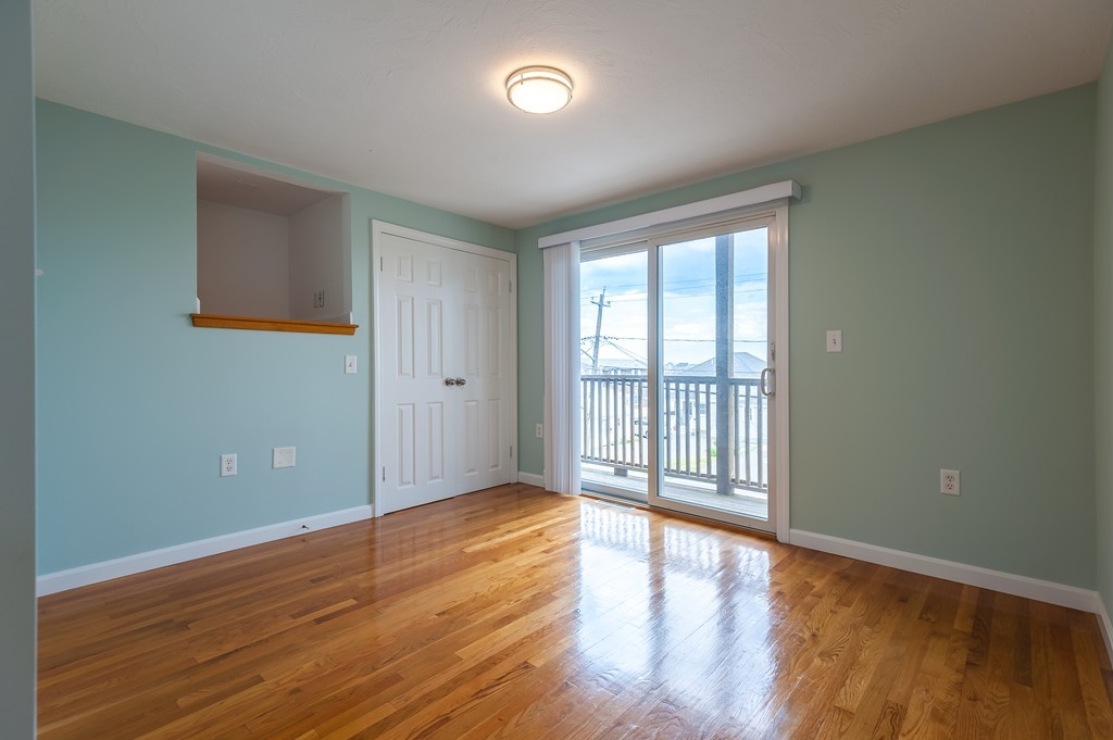 149 Jericho Road, Unit B Scituate, MA 02066 - Photo 9 of 22 a view of an empty room with wooden floor and a window