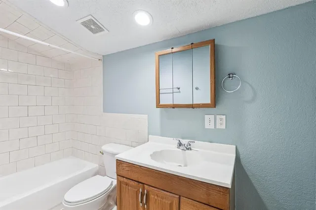 a bathroom with a sink toilet a bathtub and vanity