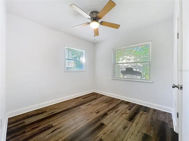 a view of wooden floor and a chandelier fan in a room