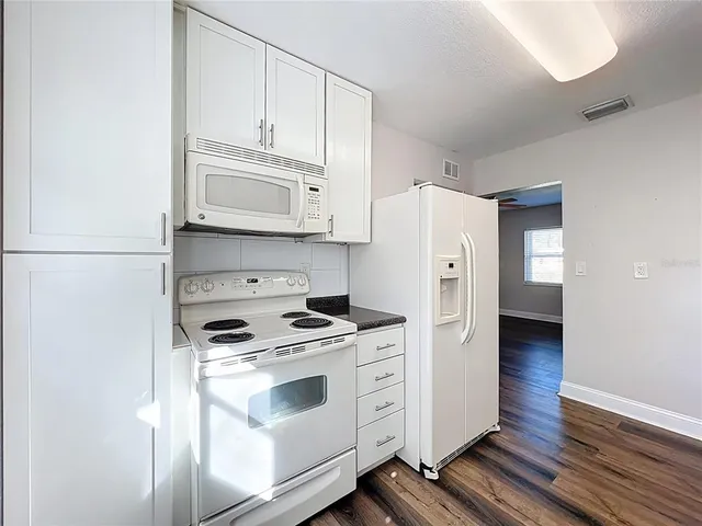 a kitchen with stainless steel appliances white cabinets and a refrigerator