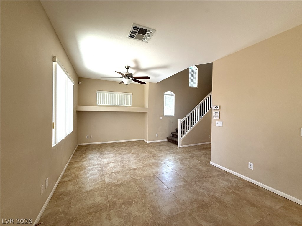 5942 Rampolla Drive Las Vegas, NV 89141 - Photo 3 of 27 A living area with elevated ceilings and a prominent staircase awaits.