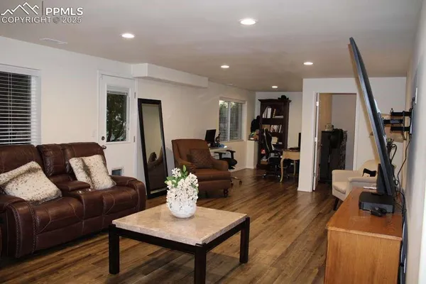 a living room with furniture and a wooden floor