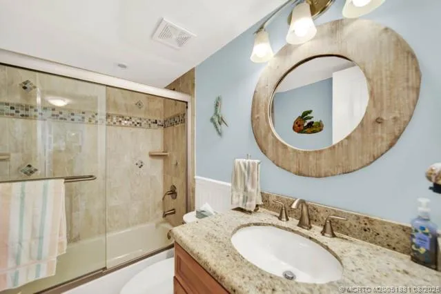 a bathroom with a granite countertop sink mirror and vanity
