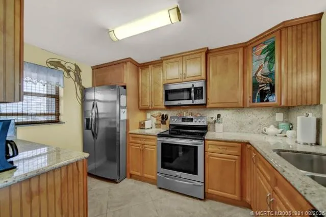 a kitchen with stainless steel appliances granite countertop a refrigerator stove microwave and sink