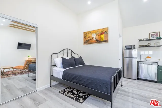 a bedroom with a bed and wooden floor