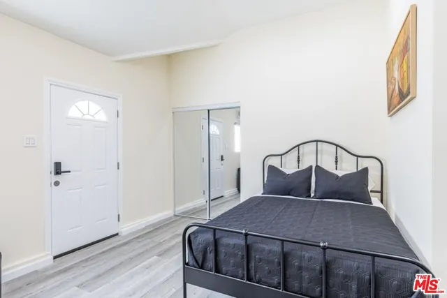 a bedroom with a bed window and wooden floor