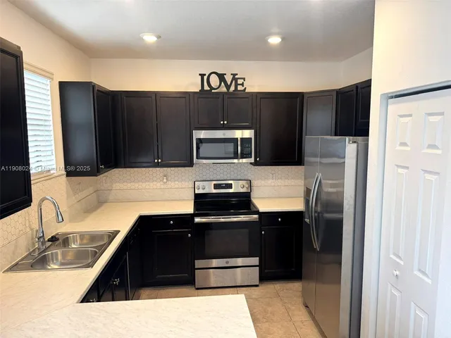 a kitchen with a refrigerator and a sink