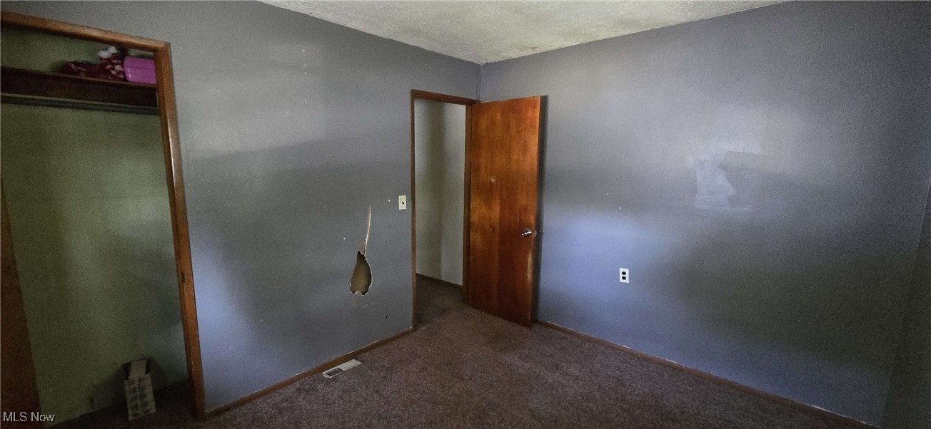 1943 Clyde Road Madison, OH 44057 - Photo 5 of 16 Unfurnished bedroom with carpet floors, a textured ceiling, and a closet