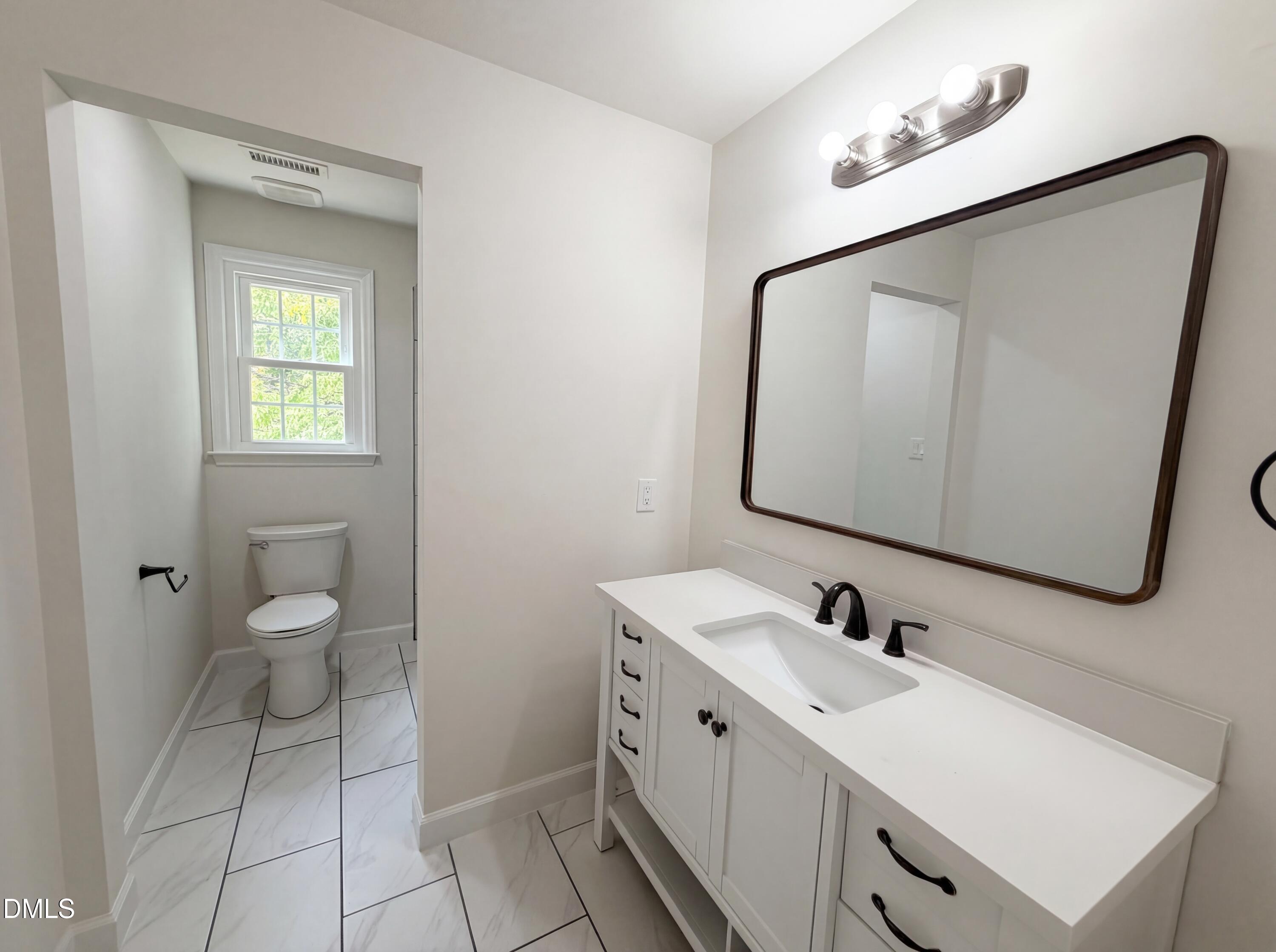 515 Gablefield Lane Apex, NC 27502 - Photo 17 of 20 a bathroom with a toilet sink and mirror