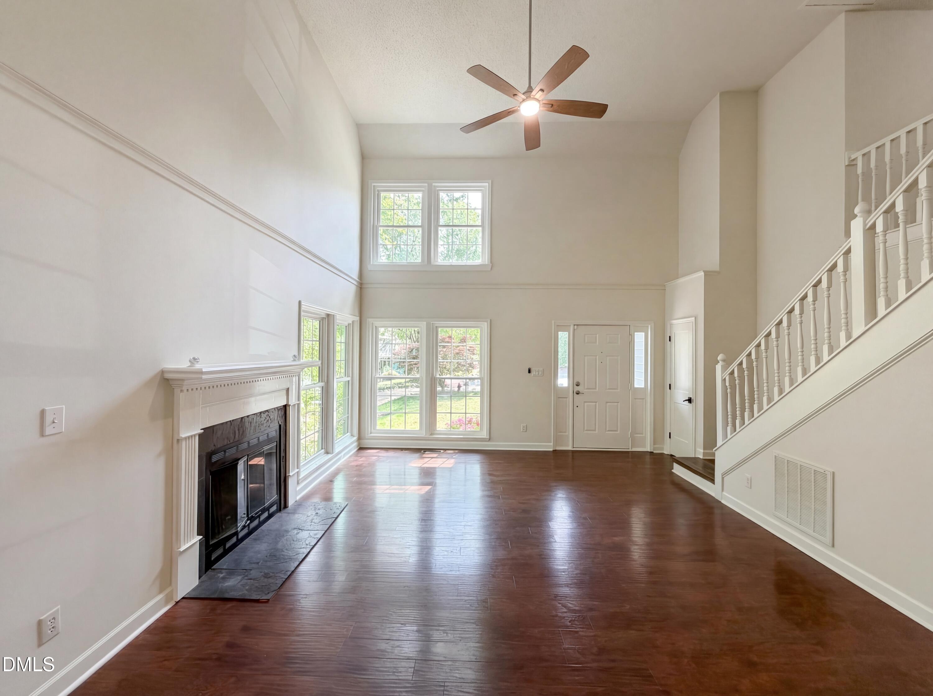 515 Gablefield Lane Apex, NC 27502 - Photo 3 of 20 an empty room with wooden floor fireplace and windows