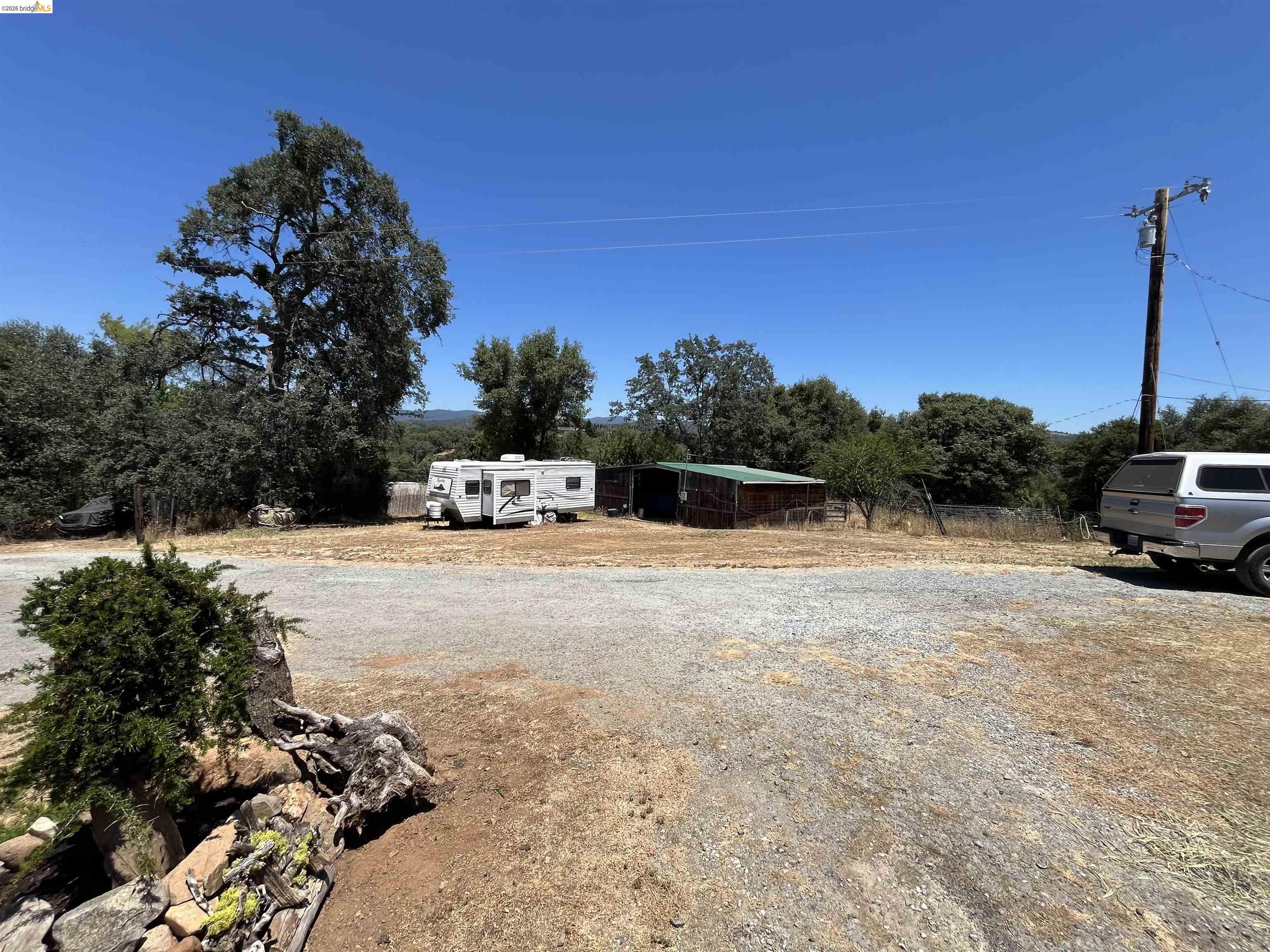 18195 Wards Ferry Road Sonora, CA 95370 - Photo 36 of 67 Gravel lot with mature trees and a utility pole