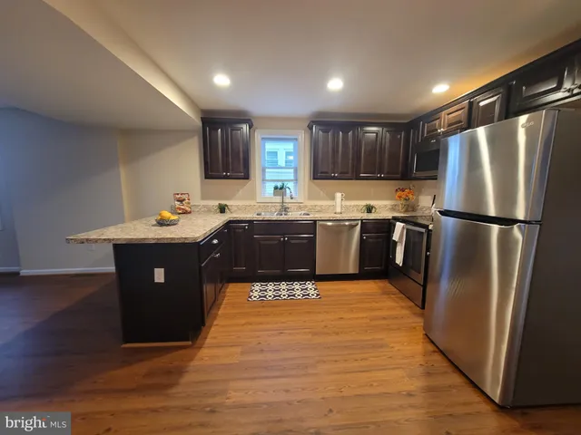 a kitchen with stainless steel appliances granite countertop a sink a refrigerator and a stove