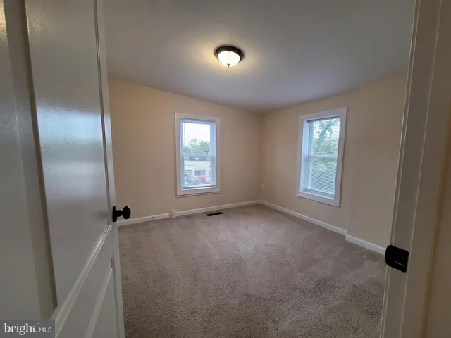 an empty room with windows and closet