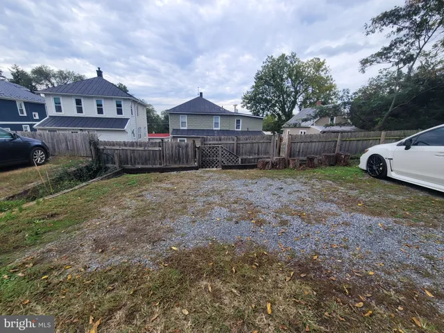 a view of a house with a yard and large trees