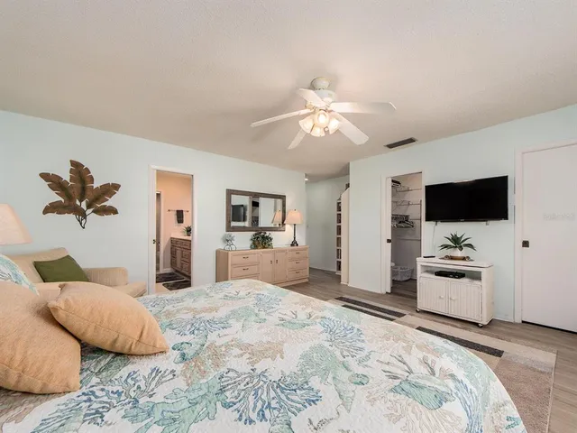 a bedroom with a bed flat screen tv and a couch