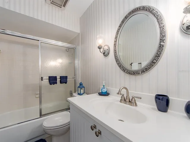 a bathroom with a sink a toilet and a mirror