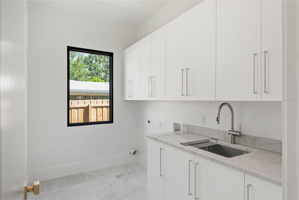 1821 Englewood Road Winter Park, FL 32789 - Photo 20 of 36 a kitchen with granite countertop white cabinets and sink