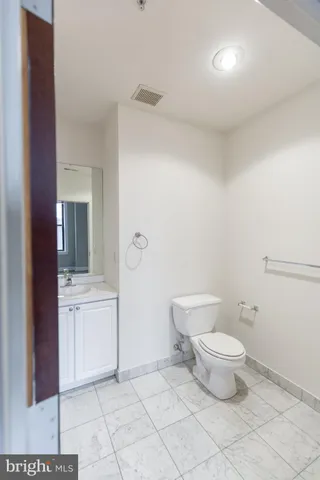a bathroom with a toilet a sink and mirror