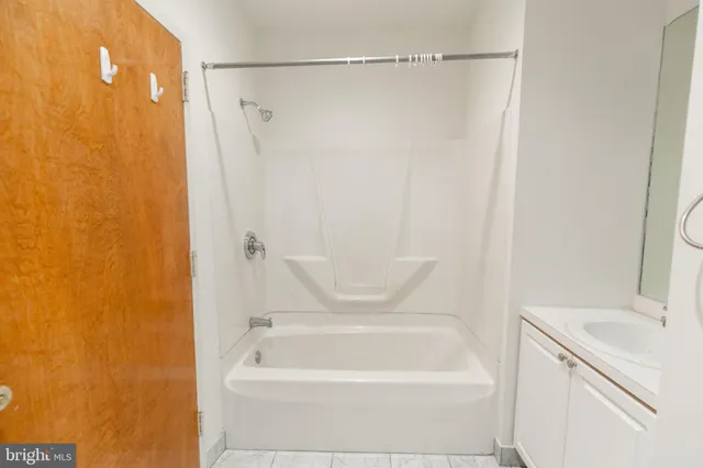 a bathroom with a tub a sink and a shower