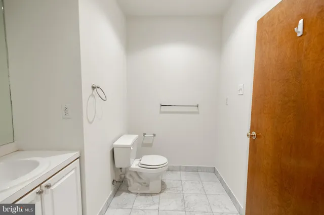 a bathroom with a granite countertop toilet and a sink