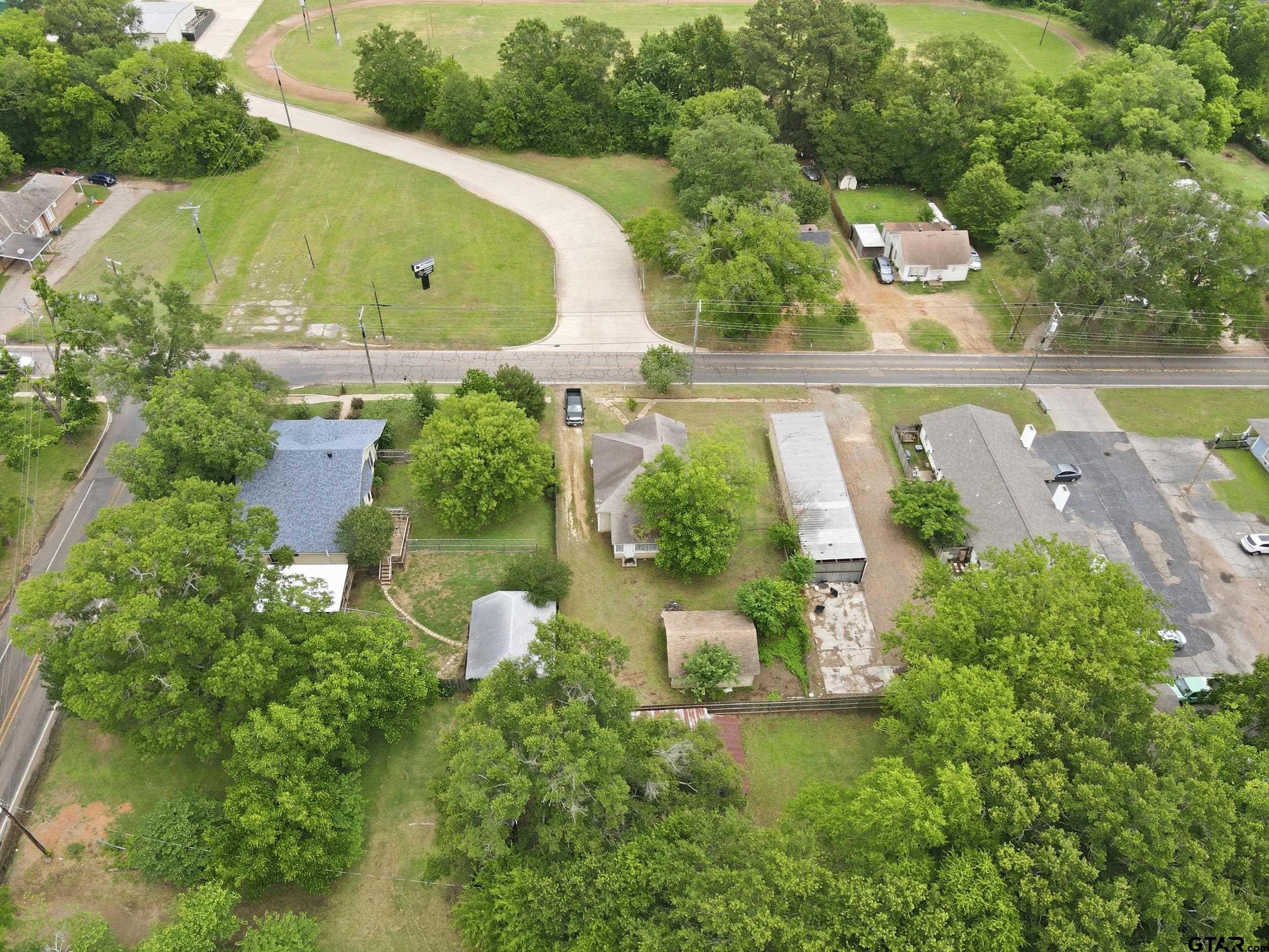 405 Rusk Street Pittsburg, TX 75686 - Photo 30 of 33 an aerial view of a house with a garden and a yard