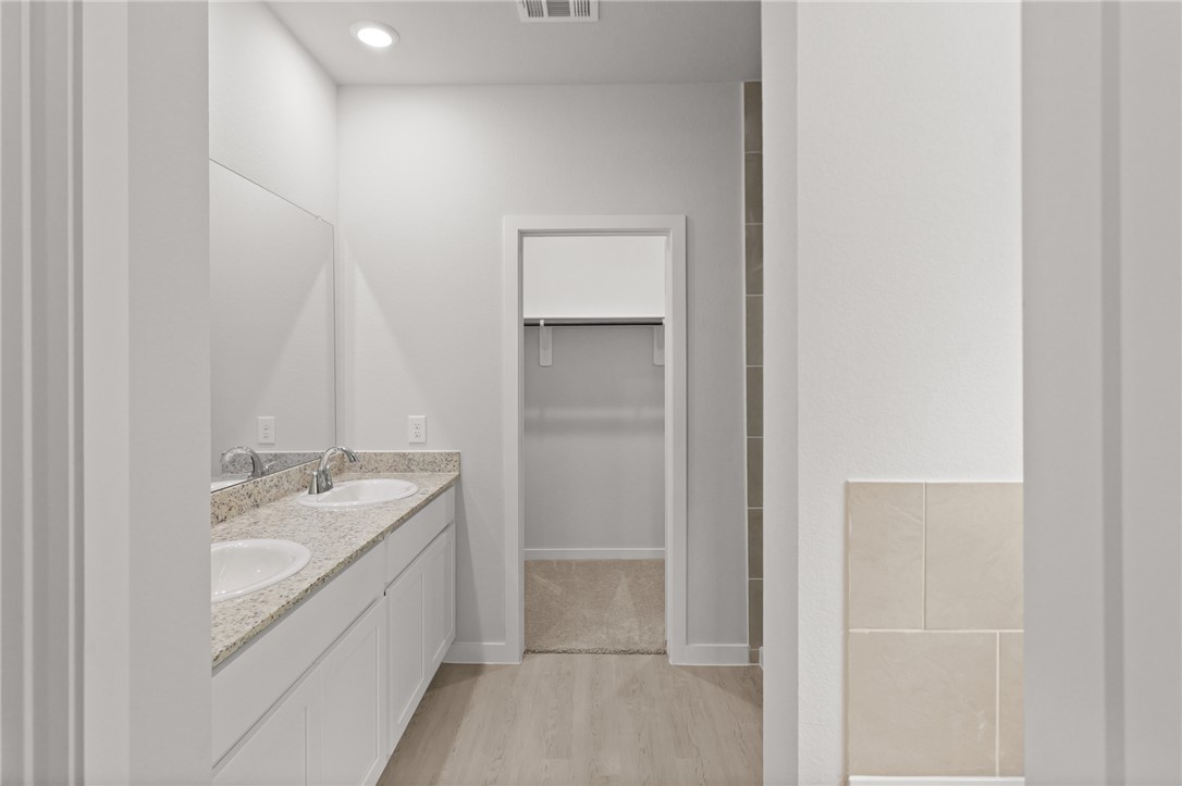 4414 Albritton Avenue Bryan, TX 77801 - Photo 22 of 30 a bathroom with a granite countertop sink a mirror and a bathtub