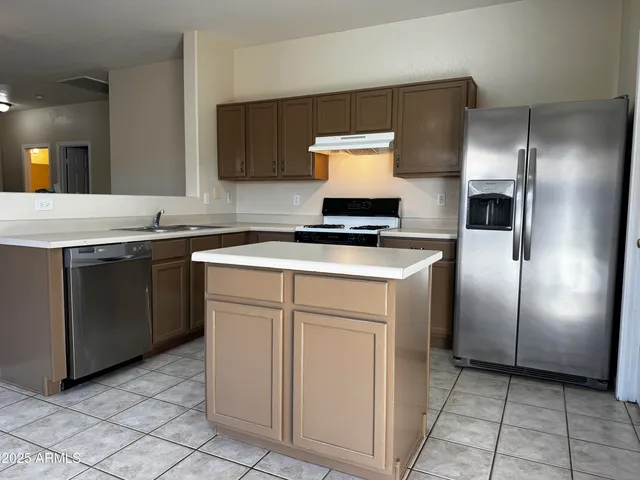 a kitchen with stainless steel appliances granite countertop a stove a refrigerator and a sink