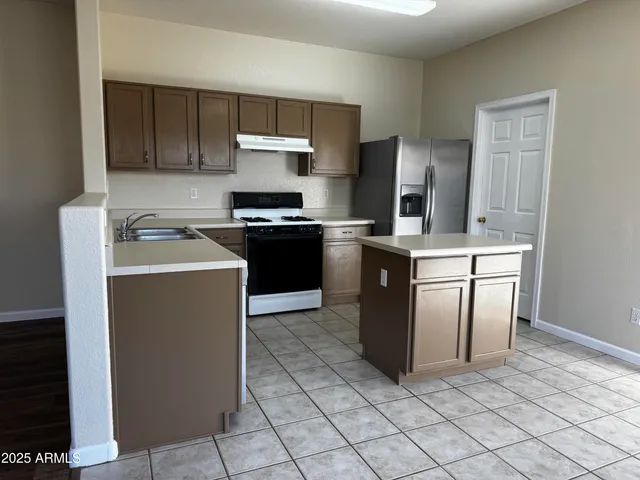 a kitchen with stainless steel appliances granite countertop a stove a sink and a refrigerator