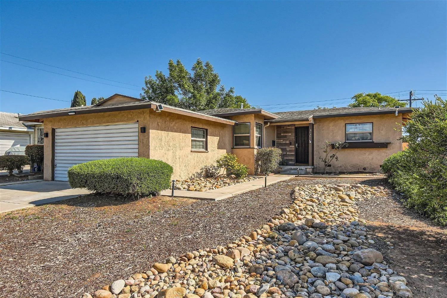 a front view of a house with a yard and potted plants
