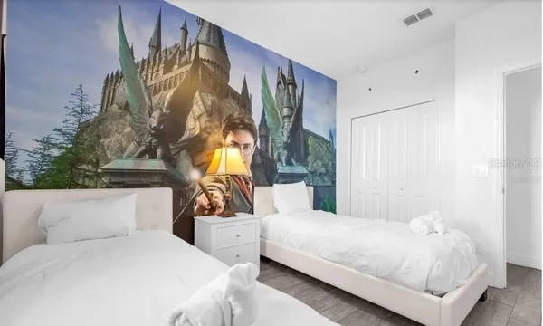 a bedroom with a bed a couch and a painting on the wall
