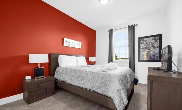 a bedroom with a bed and a flat screen tv