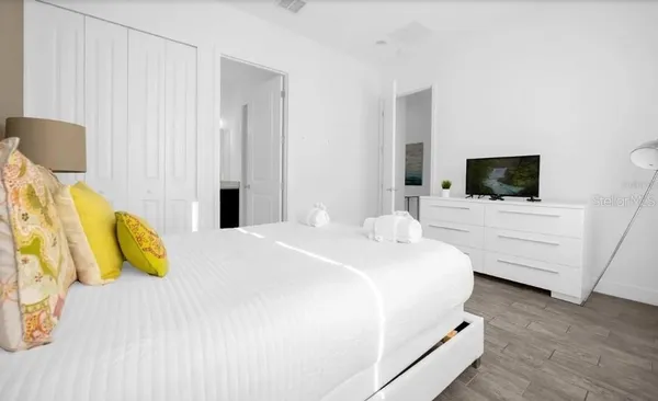 a bedroom with a bed and a flat screen tv