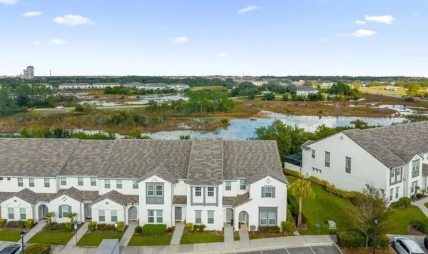 an aerial view of residential houses with outdoor space and lake view