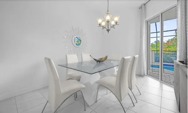 a view of a dining room with furniture a chandelier and window