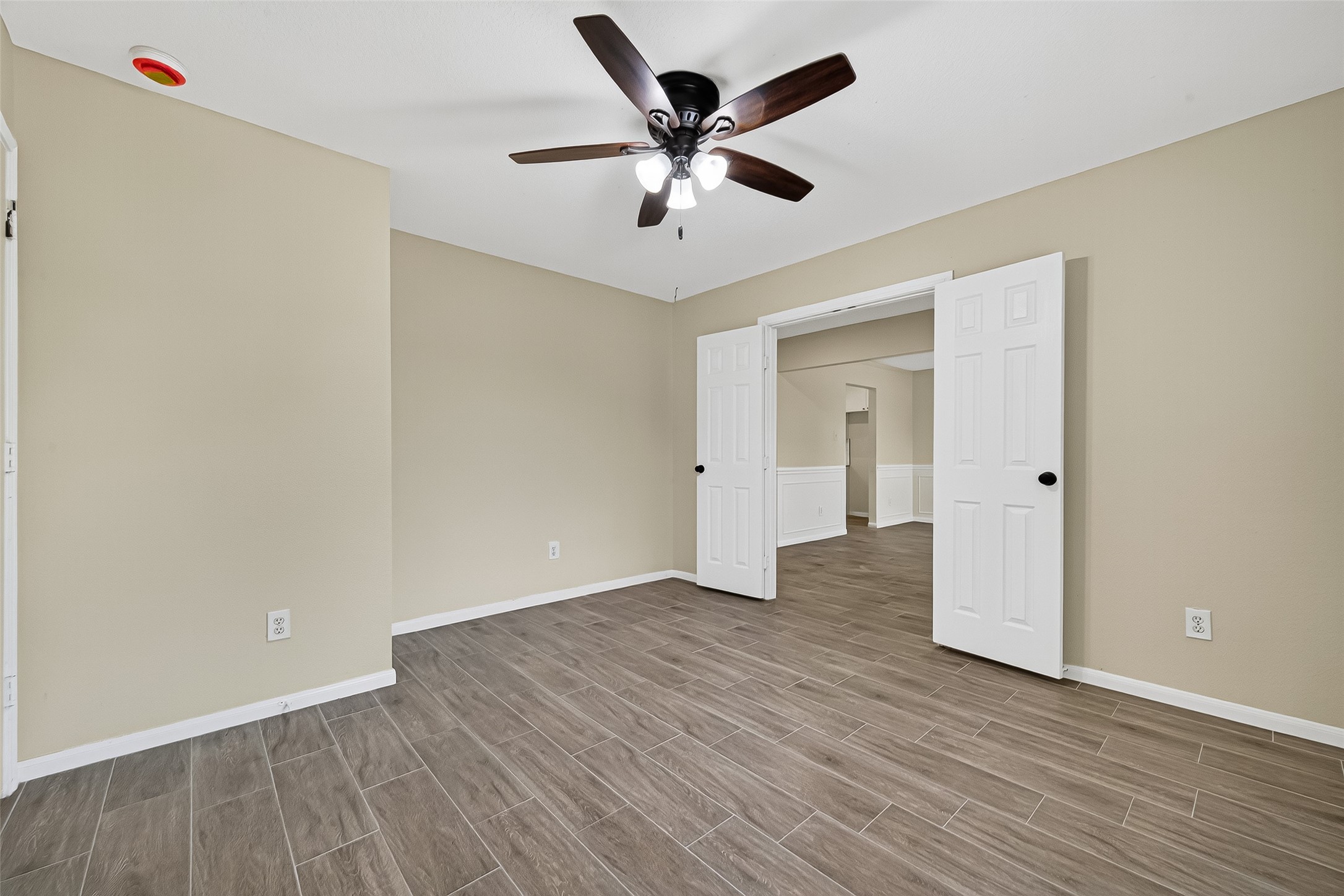 18759 Holly Way Houston, TX 77084 - Photo 12 of 46 an empty room with wooden floor and ceiling fan