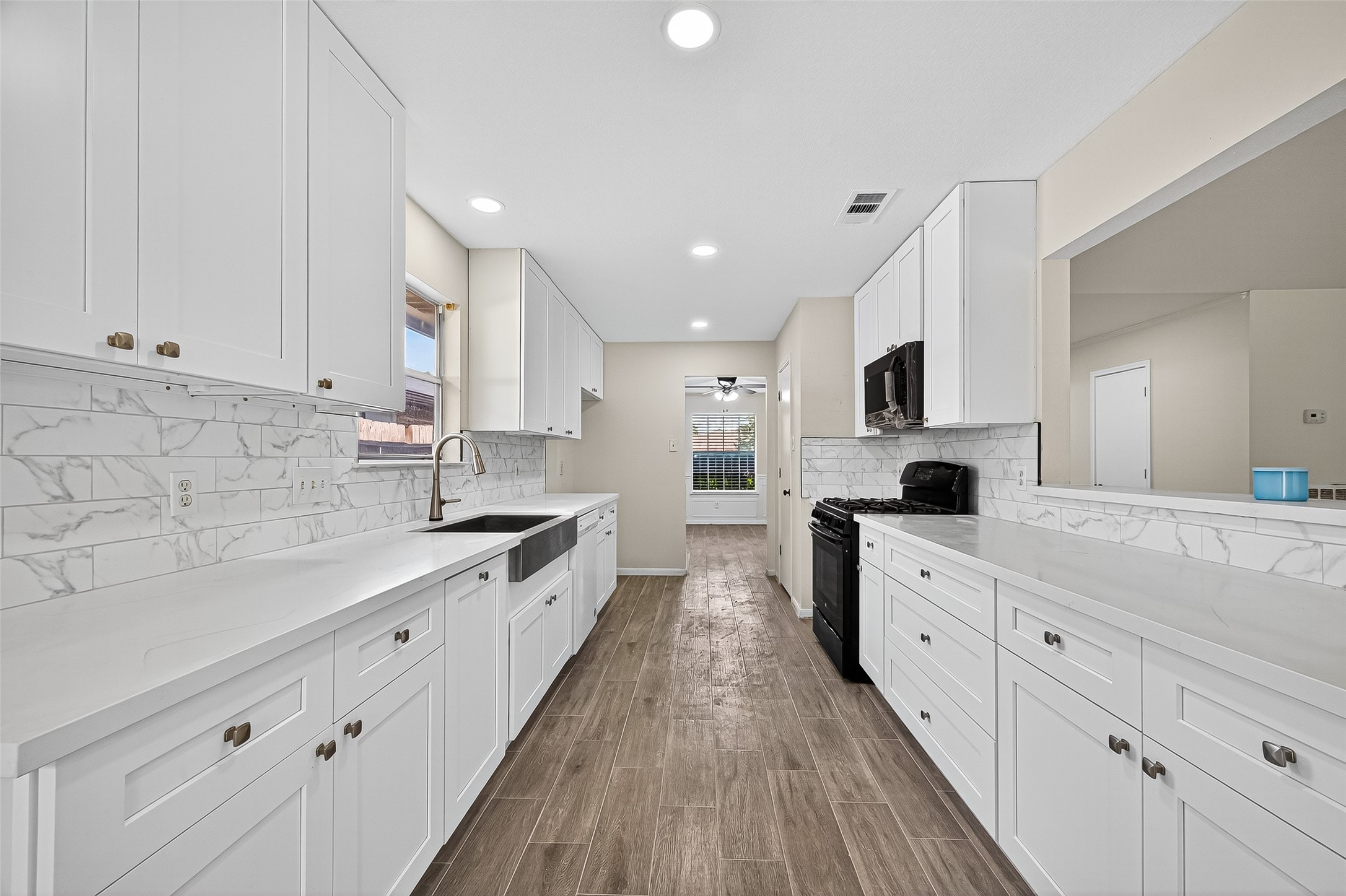 18759 Holly Way Houston, TX 77084 - Photo 22 of 46 a large kitchen with stainless steel appliances sink a stove and white cabinets