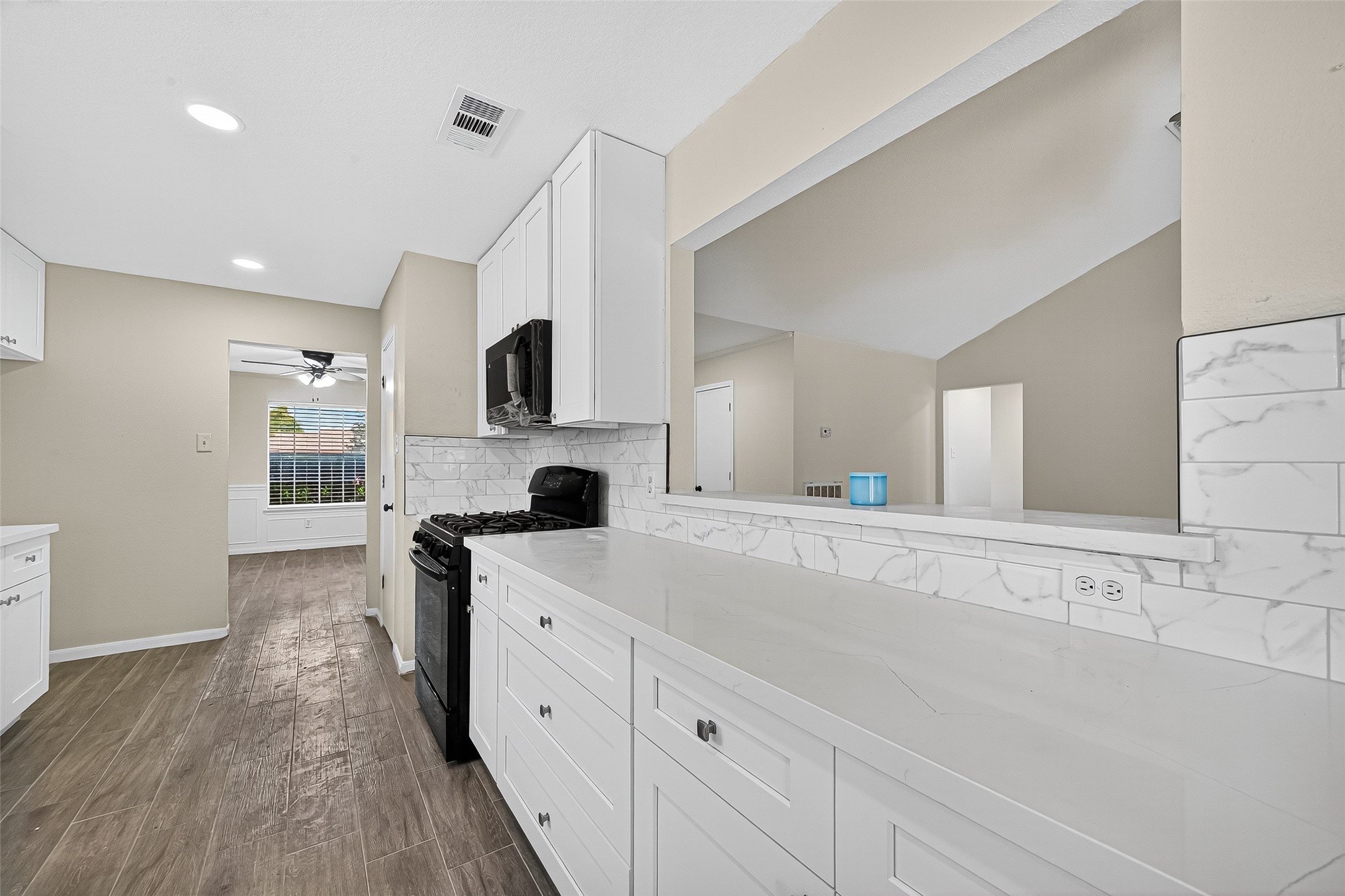 18759 Holly Way Houston, TX 77084 - Photo 23 of 46 a large white kitchen with a stove a sink dishwasher and a refrigerator with wooden floor