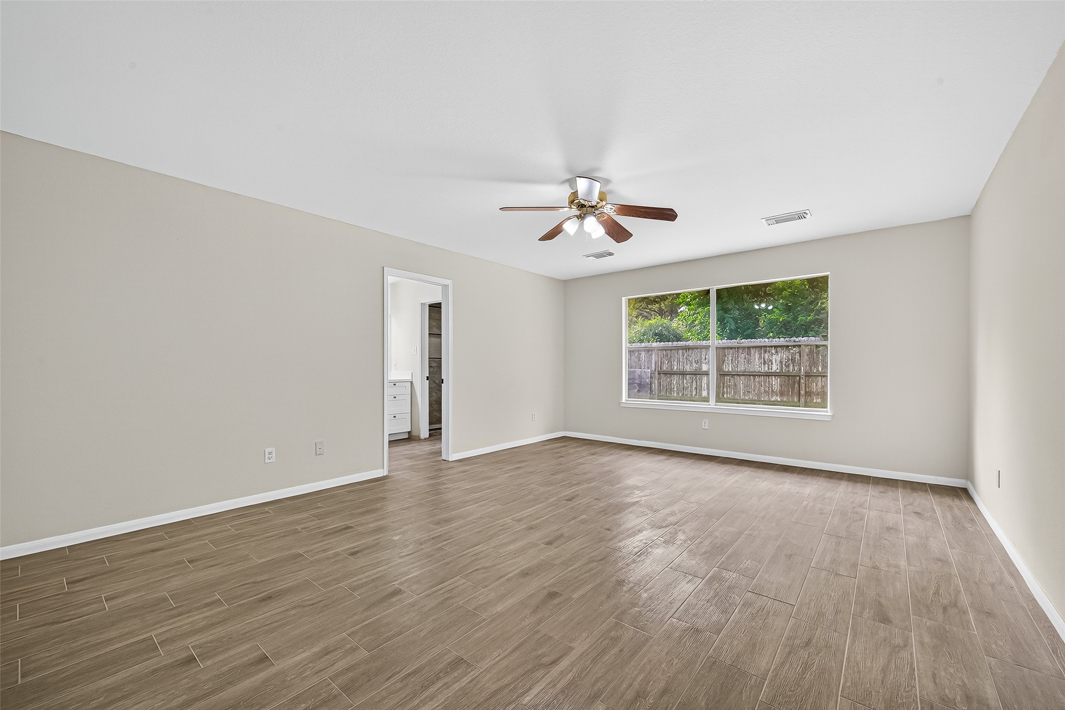 18759 Holly Way Houston, TX 77084 - Photo 29 of 46 a view of an empty room with a window and wooden floor