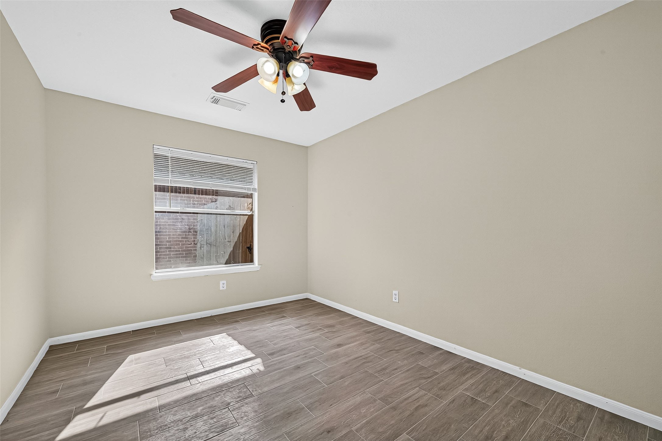 18759 Holly Way Houston, TX 77084 - Photo 37 of 46 an empty room with a chandelier fan and windows