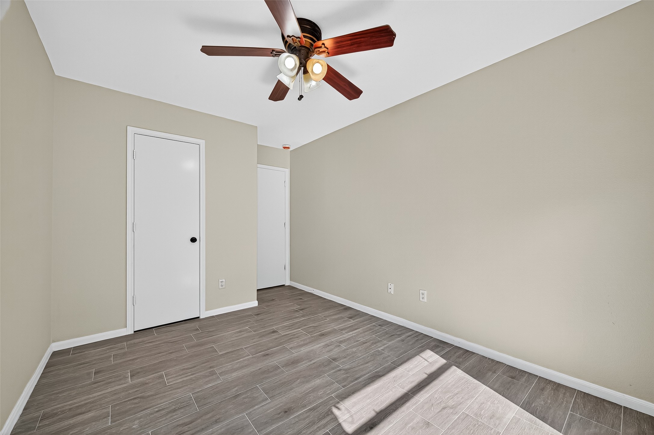 18759 Holly Way Houston, TX 77084 - Photo 38 of 46 an empty room with wooden floor and ceiling fan