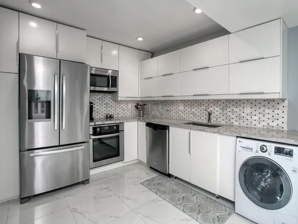a kitchen with stainless steel appliances granite countertop a refrigerator a stove and a sink