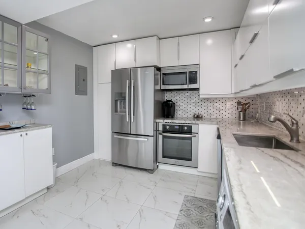 a kitchen with stainless steel appliances a refrigerator sink and cabinets